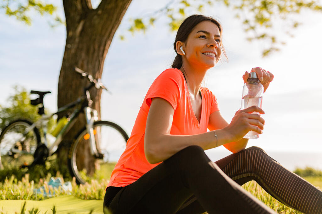 Mulher bebendo agua em um parque