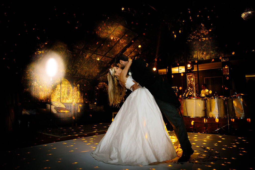 Noivos se beijando em festa de casamento